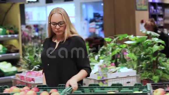 女孩在超市里选择蔬菜和水果视频的预览图