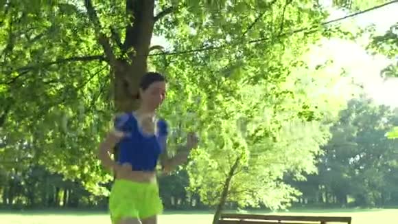 微笑的女跑步者跑在夏季公园视频的预览图