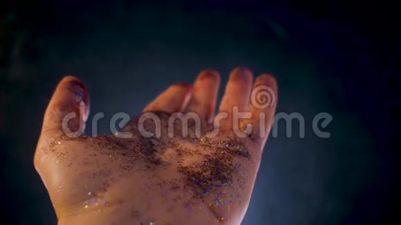 女性手上盖着亮片你的手掌和闪亮的五彩闪光视频的预览图