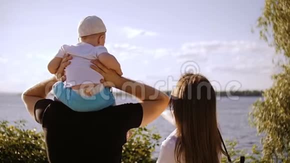 一对已婚夫妇带着一个婴儿站着看河视频的预览图