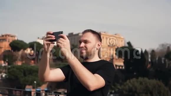 男子游客探索新城市在智能手机上拍摄城市的自拍照片男性喜欢旅行旧建筑慢动作视频的预览图