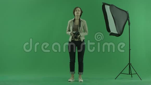 一个年轻的女人试图在绿色屏幕上拍摄一些维威尔的照片视频的预览图