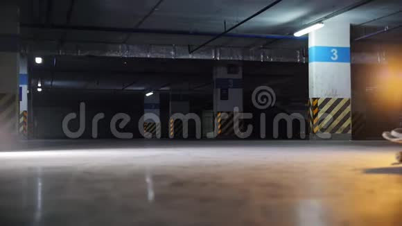 地下停车场一个年轻人在玩滑板练习技巧视频的预览图