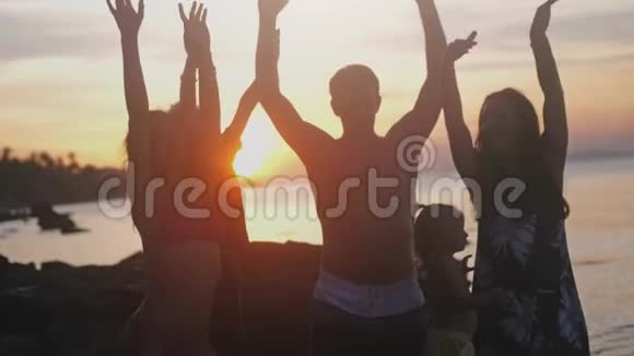 快乐的年轻朋友们和孩子们一起在热带海滩上快乐地唱歌跳舞视频的预览图
