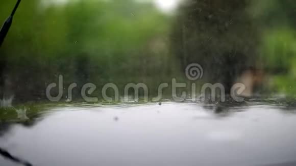 近处有大雨阵雨大雨落下来溅起水花在潮湿的黑车罩表面站立视频的预览图