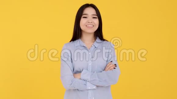 年轻的亚洲女孩在黄色背景下的镜头前显示手势OK视频的预览图
