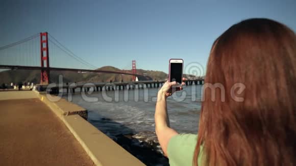 用智能手机拍照金门大桥的女人视频的预览图