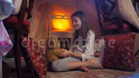 4k视频可爱的女孩坐在卧室的帐篷里拥抱着大泰迪熊视频的预览图