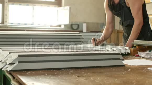 生产PVC窗户从型材男工标记尺寸在PVC型材上以进一步视频的预览图