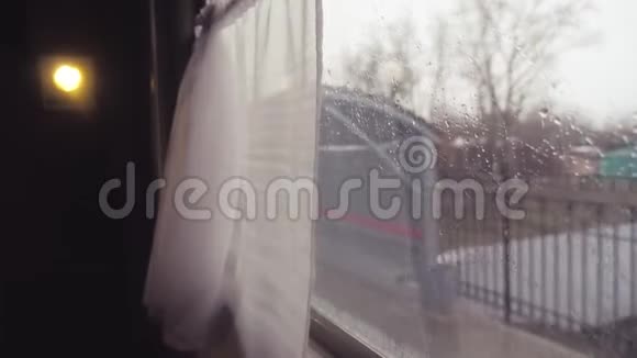 火车从火车站出发从火车窗口的视图车窗上的雨人口视频的预览图