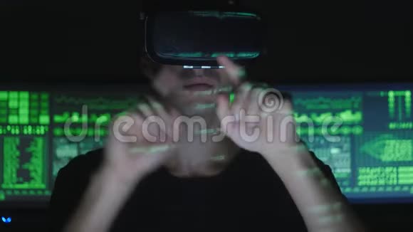 男性黑客程序员使用虚拟现实头盔编程而绿色代码字符反映在他的脸上它视频的预览图