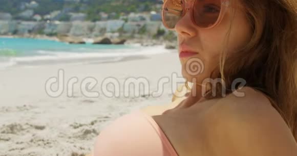 戴帽子的白人女性在海滩上放松的侧面景色视频的预览图