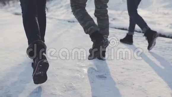 脚穿着追踪鞋在雪地里行走朋友们在雪道上散步视频的预览图