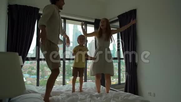 一家人在床上跳跃的慢镜头床垫和枕头概念视频的预览图