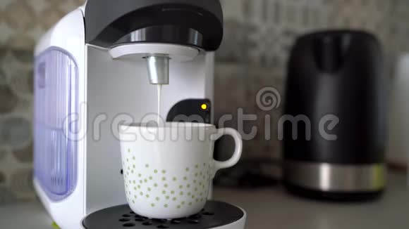 家用胶囊咖啡机准备一杯加牛奶的新鲜咖啡视频的预览图