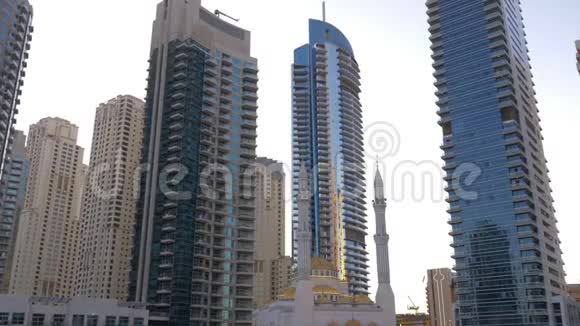 阿拉伯联合酋长国迪拜码头的穆斯林清真寺和玻璃摩天大楼城市景观玻璃立面摩天大楼视频的预览图