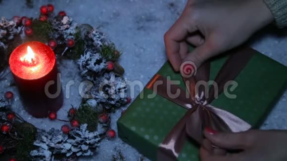 一个女人在圣诞礼物上系蝴蝶结视频的预览图