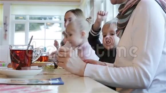 两个女人和两个孩子在桌子旁吃饭视频的预览图