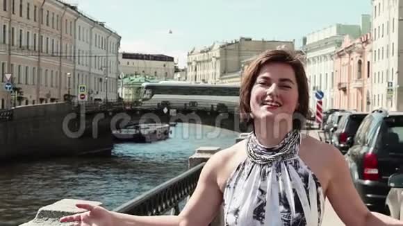 穿着斑点裙子的快乐女孩在旧市中心的堤岸唱歌视频的预览图