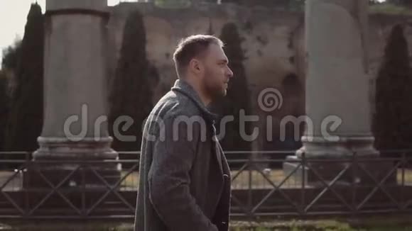 英俊的男人走在意大利罗马的废墟上盖伊做头发探索罗马论坛的建筑慢动作视频的预览图