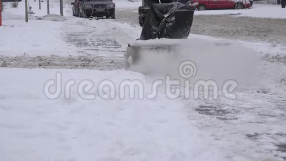 冬天在下雪的街道上带着吹雪机的工人在人行道上擦雪4K视频的预览图
