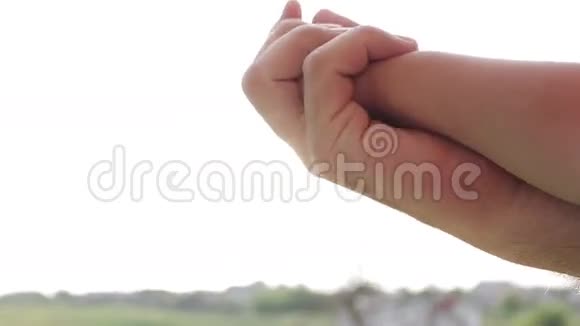 孩子的手掌和阳光下的人视频的预览图