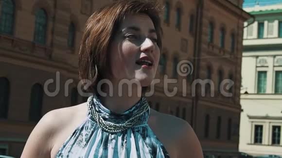 年轻的歌唱家女人穿着夏装在老城区表演视频的预览图