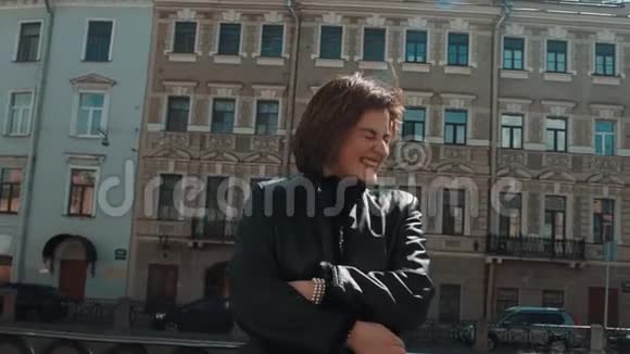 年轻的歌手女孩穿着黑色皮夹克在老城区表演视频的预览图