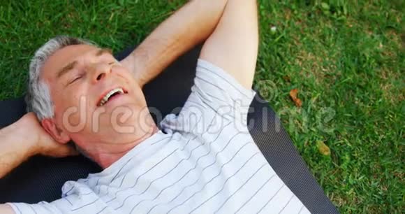 4k花园里躺在运动垫上的老人视频的预览图