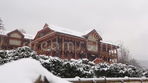 大雪时山村的木屋背景为针叶林落在木头上的雪视频的预览图