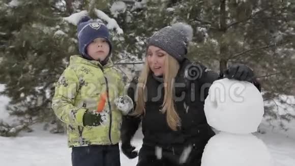 妈妈和儿子堆雪人视频的预览图