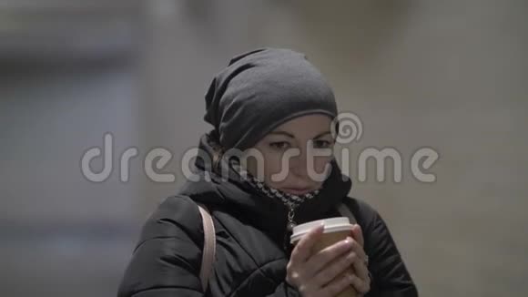 冬天漂亮的女人在隧道里取暖喝热咖啡视频的预览图