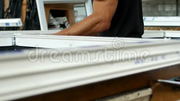 制造和制造PVC窗户一名男性工人在PVC框架中安装橡胶密封组装PVC视频的预览图
