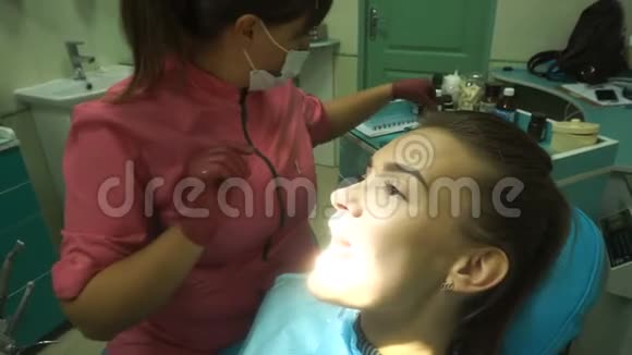 漂亮的年轻女孩对待她的牙齿视频的预览图