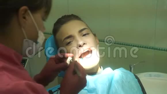 年轻迷人的女人对待她的牙齿视频的预览图