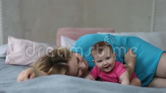 慈爱的年轻母亲亲吻她的女婴视频的预览图