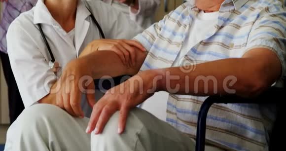 女医生跪在轮椅上与残疾老人交谈视频的预览图