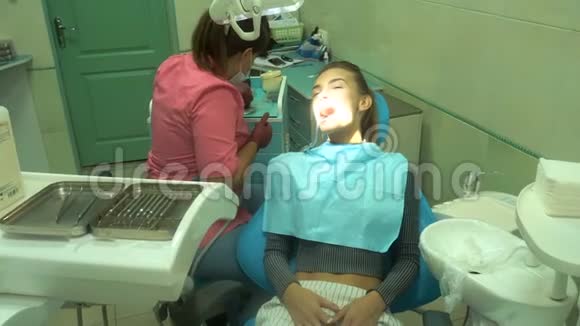 迷人的年轻女孩对待她的牙齿视频的预览图