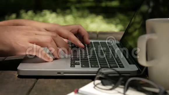 自由职业者在公园绿色自然背景的电脑手提电脑视频的预览图
