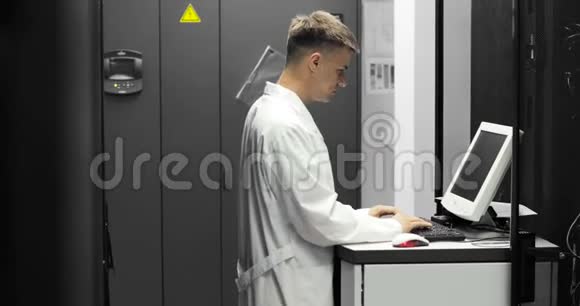 IT技术人员在大数据中心的一台电脑上工作里面装满了Rack服务器他运行诊断和维护系统视频的预览图