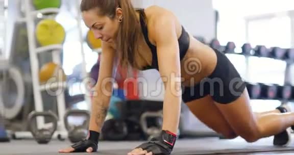 受过良好训练的女人在健身操垫上做俯卧撑视频的预览图