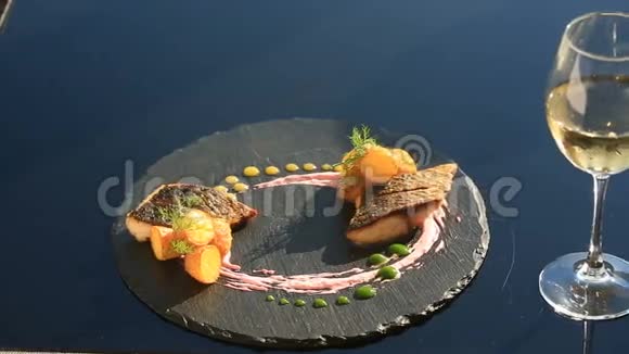 一盘高级菜肴特写镜头小土豆鱼骡子一杯白葡萄酒Primorsik餐厅视频的预览图