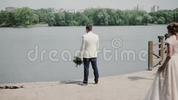 他们结婚那天很恩爱新郎在码头上美丽的新娘向他走来他转身吻她视频的预览图