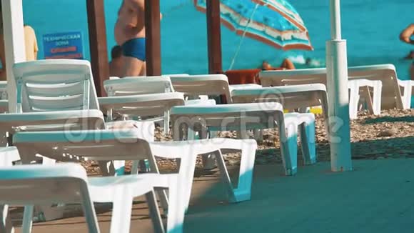 白色海滩的懒汉沙滩伞躺椅让您在蓝天上放松在海滩上有沙发视频的预览图