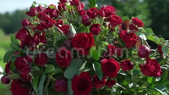 夏日阳光明媚的乡村举行的婚礼上红玫瑰鲜花组合花束视频的预览图
