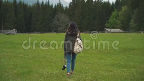 带背包和照相机的女孩在森林附近散步视频的预览图