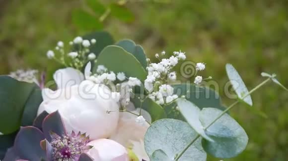 美丽的婚礼花束躺在草地上视频的预览图