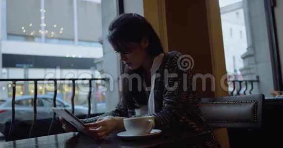 有平板电脑的女人在咖啡馆喝咖啡4k视频的预览图