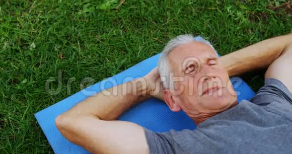 4k花园里躺在运动垫上的老人视频的预览图