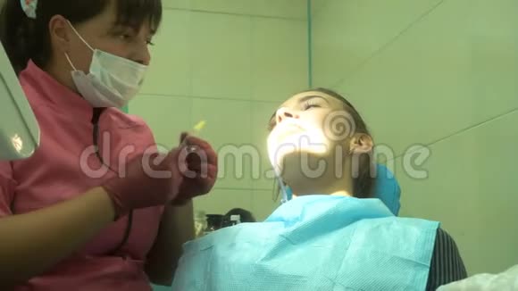 年轻迷人的女孩对待她的牙齿视频的预览图